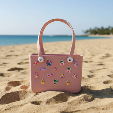 Pink crocs bag with decorative stickers on the sand