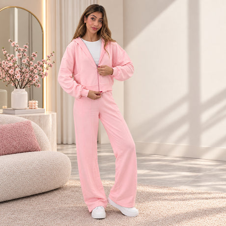 Pink cotton zip hoodie worn half zipped over a white tee with matching seam front wide leg pants