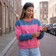 Pink sweatshirt with a denim yoke and denim sleeves worn with light blue jeans