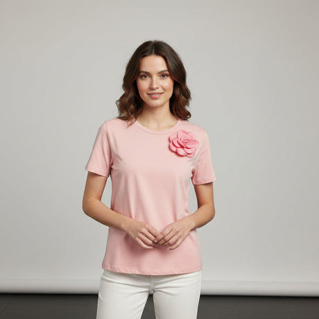 Woman wearing a pink tshirt with a flower design on a gray background