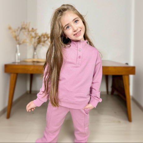 Girl in a dusty pink button placket sweatshirt and matching pants