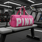 Bright pink gym duffle bag with bold logo print, top handles and adjustable shoulder strap