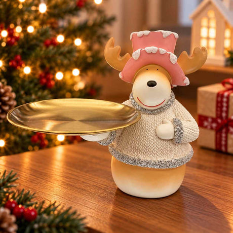 Reindeer figurine in a pink frosted top hat and cream sweater holding a round golden tray