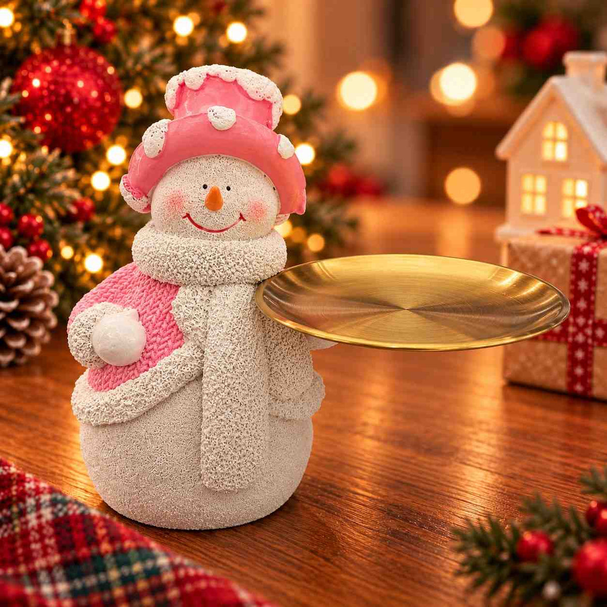 Snowman figurine in a pink frosted top hat and scarf holding a round golden tray