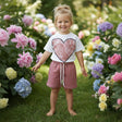 Girl in a white lace heart print tee and dusty rose shorts