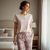 Woman wearing a pink pajama set in a bedroom