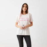 Pink tshirt with the text "Breathe deep drink water" worn by a woman holding a bottle with a white bakground