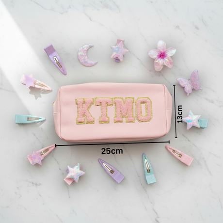 Pink pouch with 'KTMO' branding with measurements 13x25cm on a white background with hair accessories
