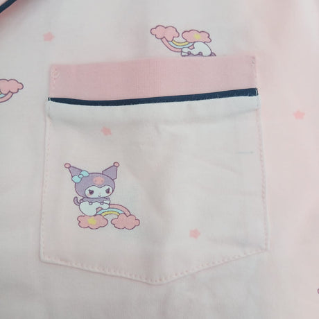 Chest pocket close up on a pink kids pyjama top with navy piping and a cartoon character print