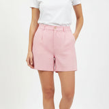 Person wearing pink linen shorts and a white tshirt on a white background