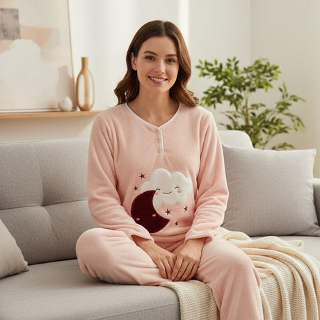 Pink fleece pyjama top with a white cloud and burgundy crescent moon applique, worn seated on a sofa