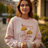 Close view of golden mushroom embroidery and rust script on blush pink fleece