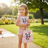 Girl wearing a pink two piece swimsuit with a ballerina panda print, holding a matching tote bag