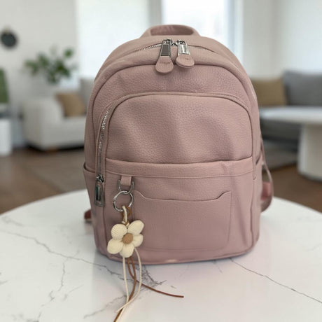 Blush backpack resting on a marble table in a bright living room