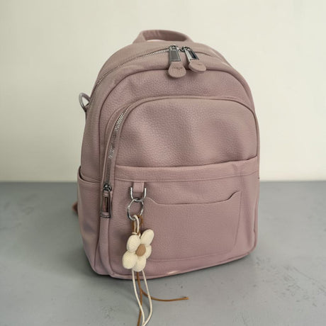 Dusty pink pebbled faux leather backpack with a cream beaded flower charm