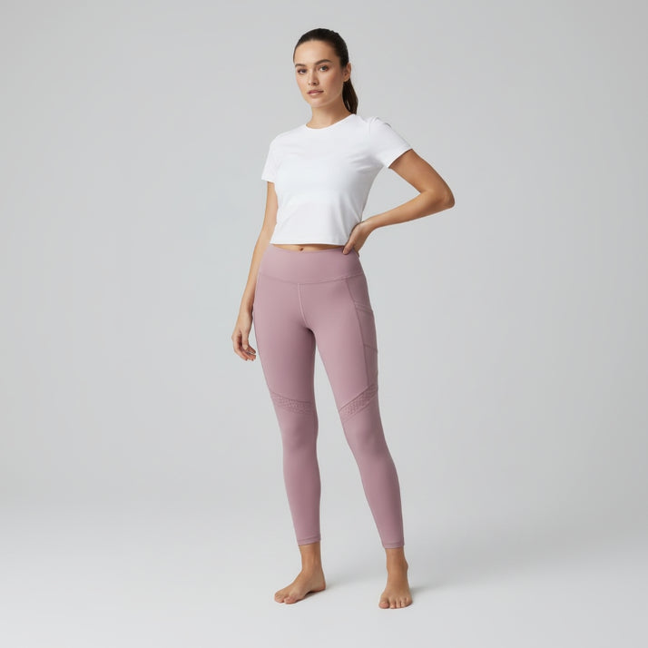 Woman wearing pink leggings and a white tshirt on a grey background