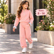 Girl walking in a peach pink half zip jogging set with white piping, ruffle cuffs and white sneakers