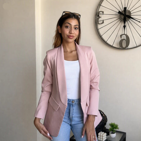 Pink blazer layered over a white ribbed vest with high waisted blue jeans