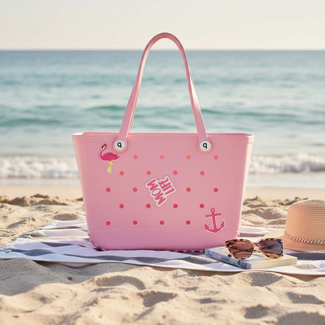Pink tote bag with flamingo design on a sandy beach