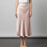 Person wearing a pink skirt on a plain background