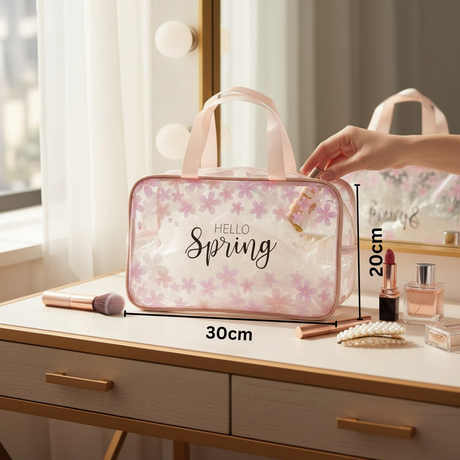 Pink floral cosmetic bag with 'Hello Spring' text on a vanity table