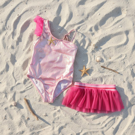 Pink starfish swimsuit and tulle skirt flat lay with shell props