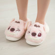 Blush Angel mules with maroon markings, one eye open and one winking, on pale wood