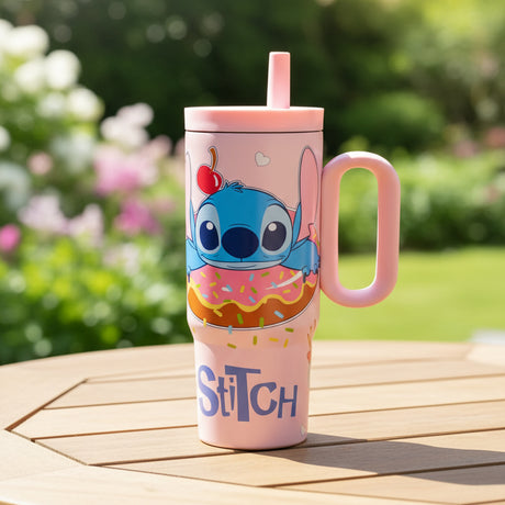Pink Stitch donut print tumbler on a garden table with flowers behind