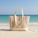 Striped tote bag with a pattern of pink, gold, and beige on a store shelf.