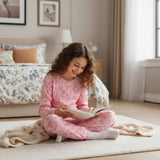 Girl in a pink teddy bear outline print pajama set reading
