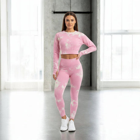 Woman wearing a pink athletic outfit with white floral patterns in a bright room