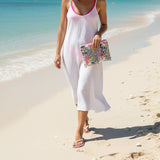 Flip flops and pouch with floral and leopard print design on sand