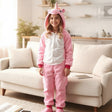 Girl standing in a pink unicorn onesie with the hood up