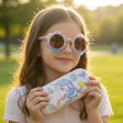 Kids sunglasses with pastel flower shaped frames and a white glitter hard case printed with a unicorn