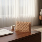 Woven clutch on a wooden surface with a blurred background