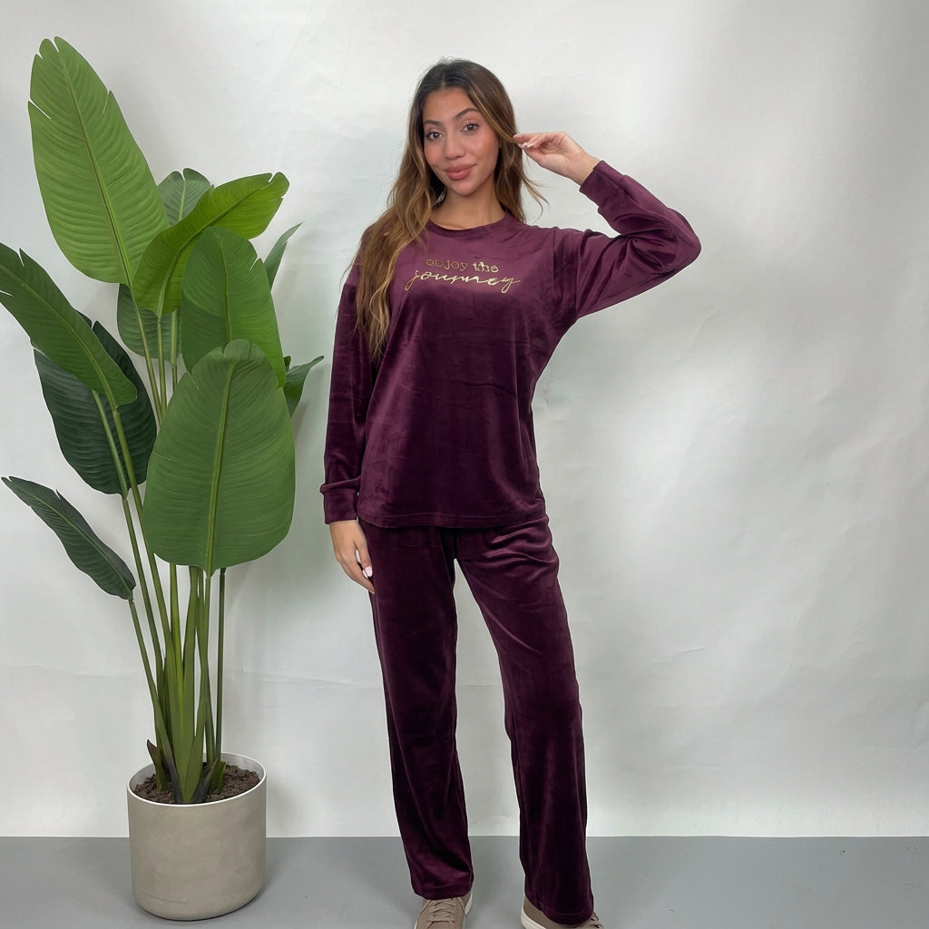 Woman in a plum velvet PJ set with Enjoy The Journey gold print top and straight pants