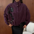 Plum oversized jacket with a black sequin flower trail, high snap collar and belted hem