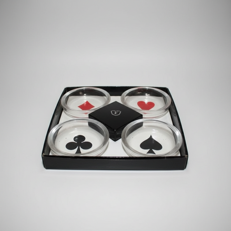 Set of four clear ashtrays with playing card suits in a black box on a light grey background