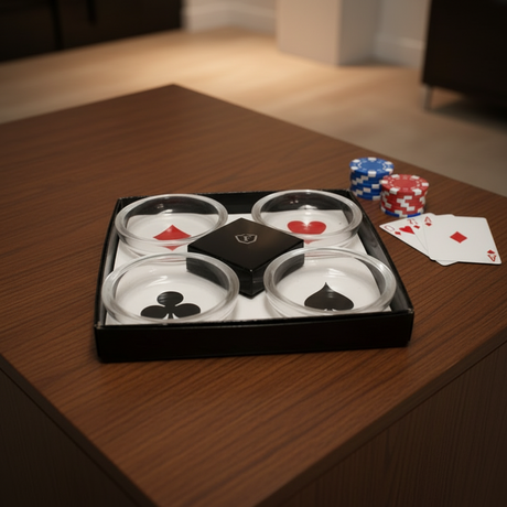 Four dice cups with playing card symbols on a wooden table with poker chips and cards