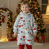 Boy wearing a polar bear print fleece hooded blanket in front of a Christmas tree