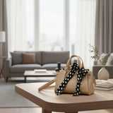 Beige mini handbag with black and white polka dot scarf tied at the handle