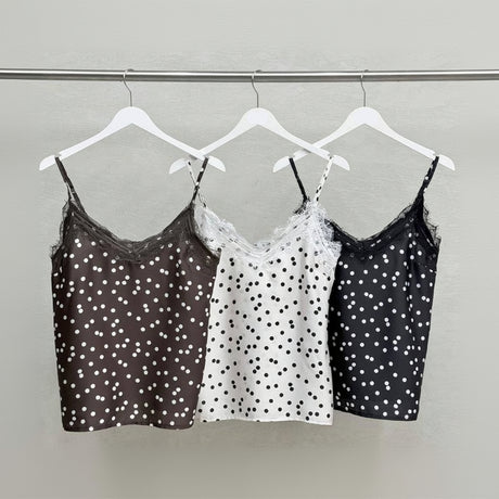 Three polka dot camisoles hanging on a rack
