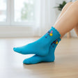 Kids turquoise crew socks with frilled lettuce cuffs and a Stitch holding a yellow pompom print