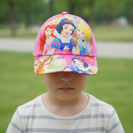 Pink kids baseball cap printed with three cartoon fairytale princesses, worn by a child in a park
