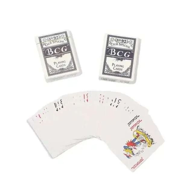 Two sealed decks of playing cards with a fanned arc of cards below them