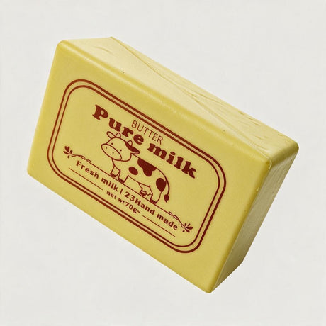 Angled yellow butter block squishy showing its cow label and smooth sides
