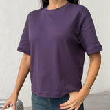 Person wearing a purple tshirt and blue jeans against a plain background