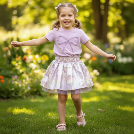 Girl in a lilac ruffle bow tee and a shimmering tulle skirt
