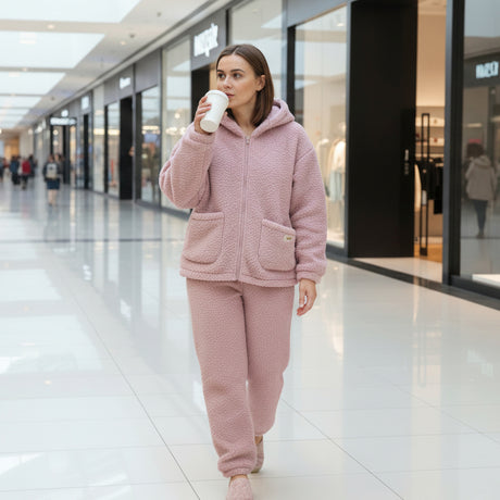 Woman in the mauve fleece hoodie set with front pockets, sipping coffee in a mall
