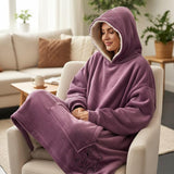 Curled in a boucle armchair, hood raised, in a dusty mauve blanket with an ivory sherpa lining